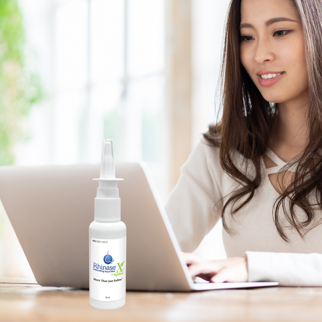 Woman using a laptop with a Rhinase X next to it