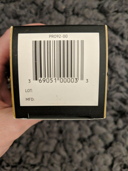 Bar code label on a product packaging held by a hand against a textured gray background